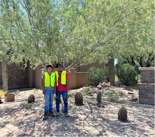 Two TC Lighting crew members in high-visibility vests on a desert property in Arizona